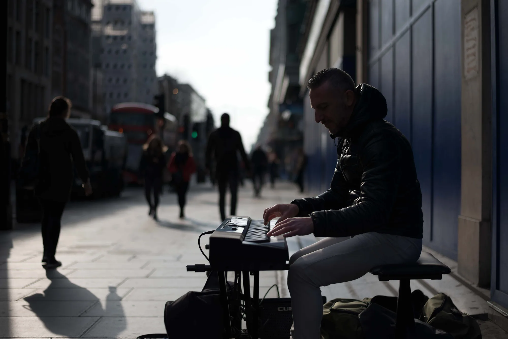 A man sitting beside a reflective city building
