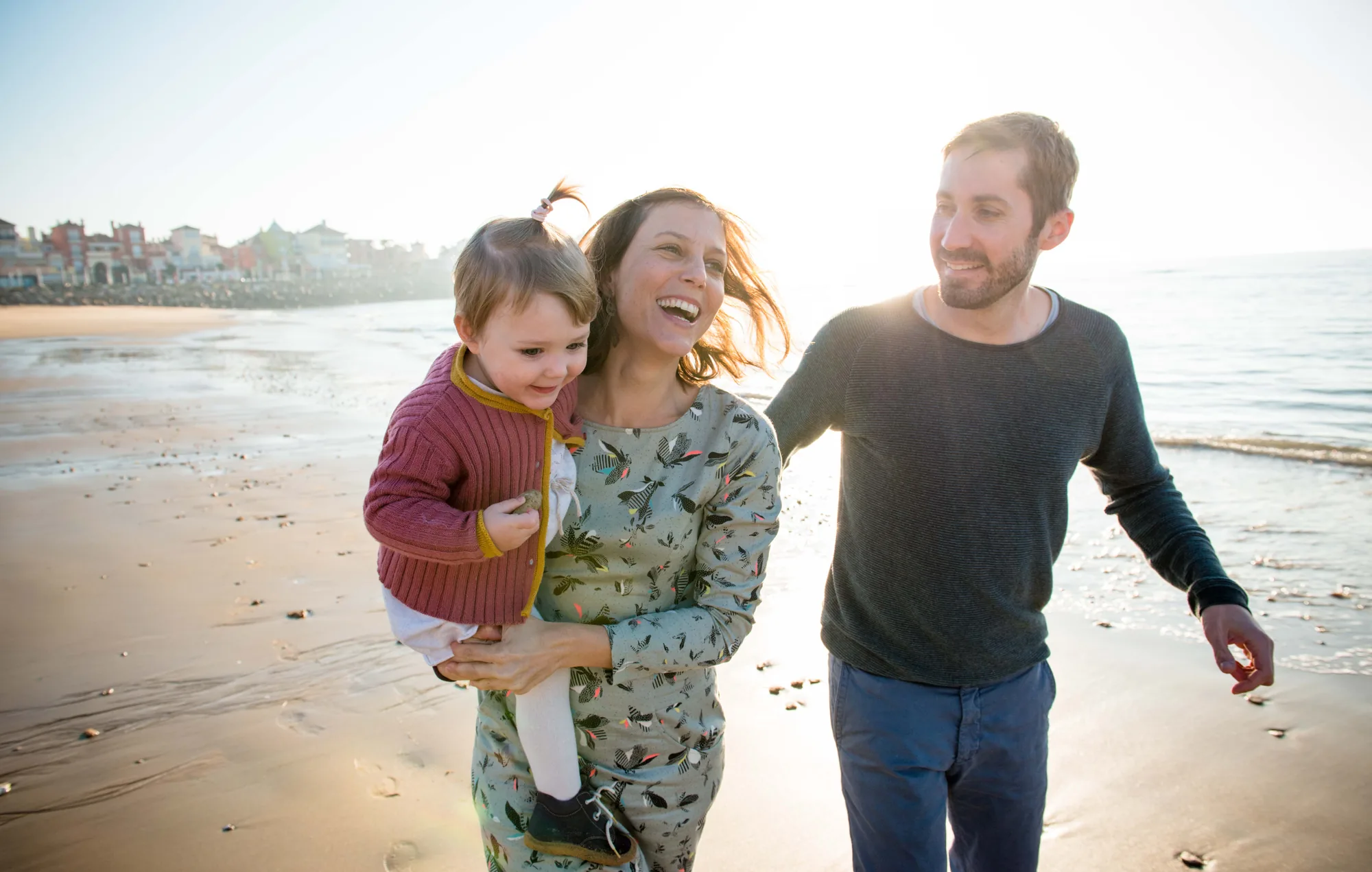 A smiling family walking on the beach