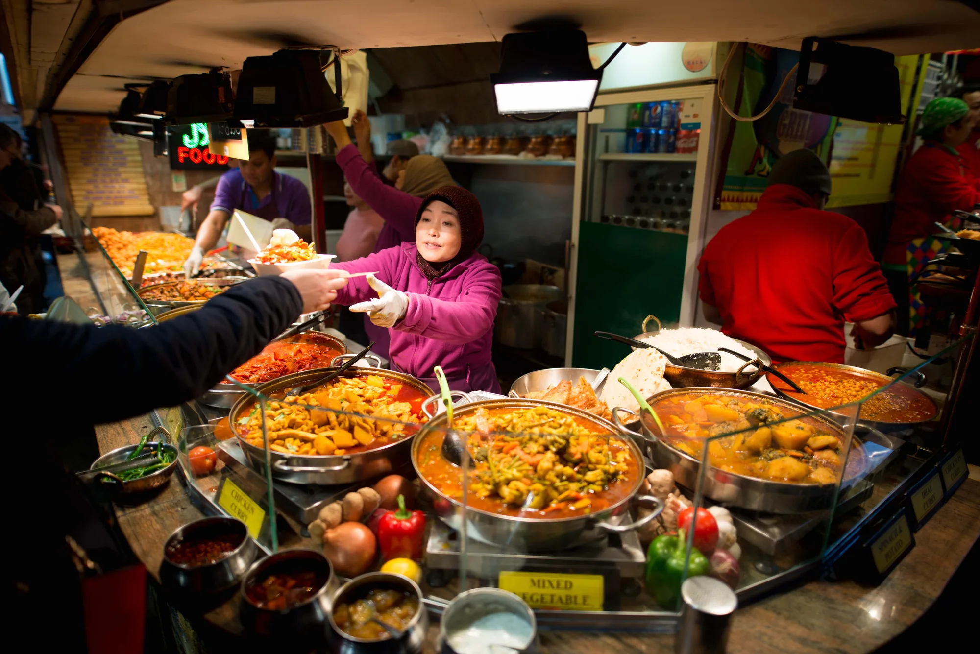 A colourful food market full of vendors and customers