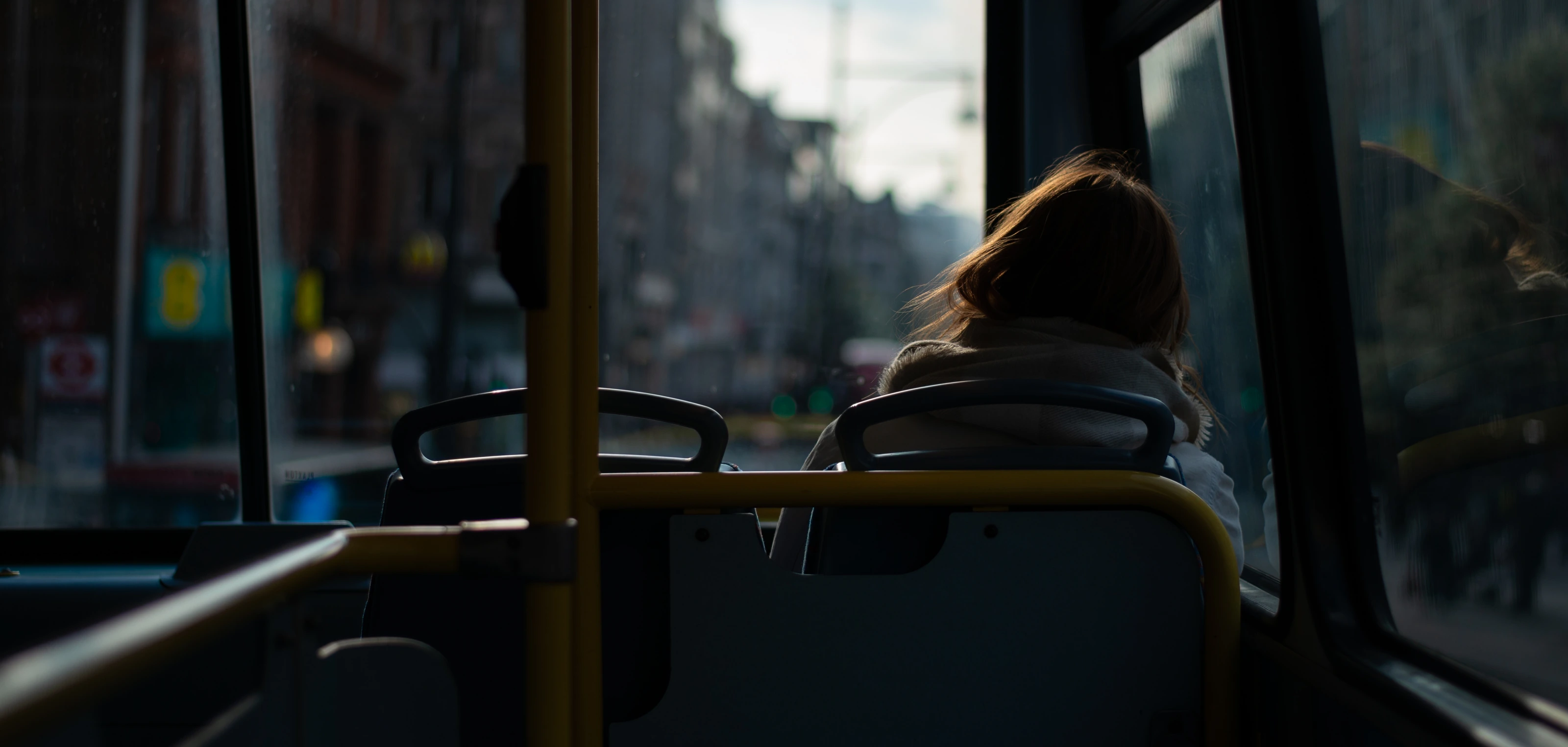 A solitary passenger seen from the back of a London bus