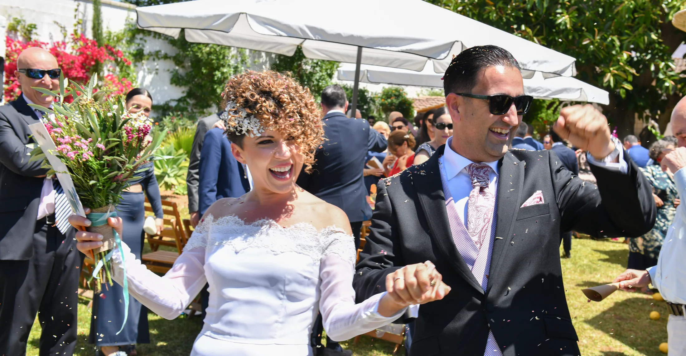 A newly married couple laughing as they leave their ceremony